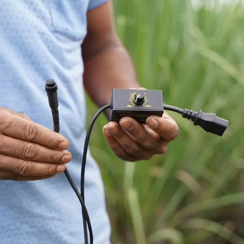 SWASTI Auto Soil Drenching Device image 1: SWASTI controller with a Min to Max dial, cable and plug held in the hand